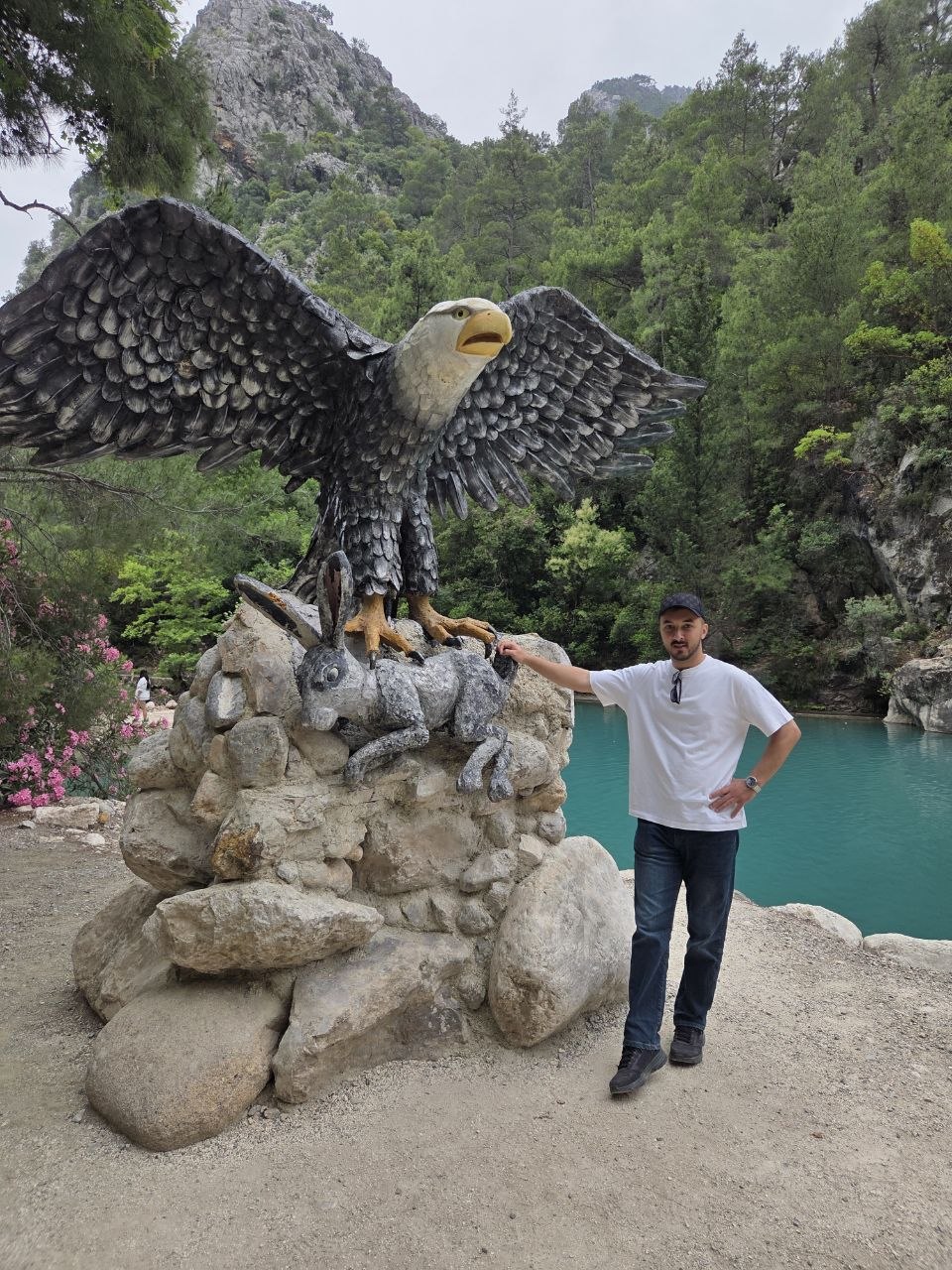 Emre standing beside an eagle sculpture
